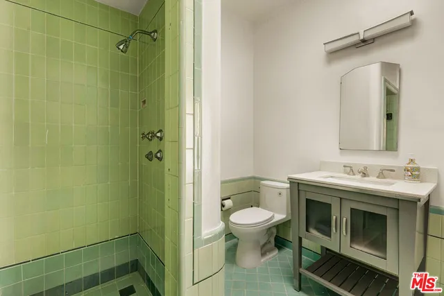 a bathroom with a granite countertop toilet sink and mirror