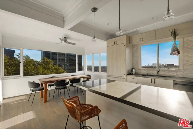 a dining hall with stainless steel appliances granite countertop a kitchen island a stove and a sink