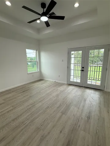 an empty room with wooden floor and windows