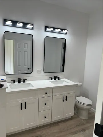a bathroom with double sink and a mirror