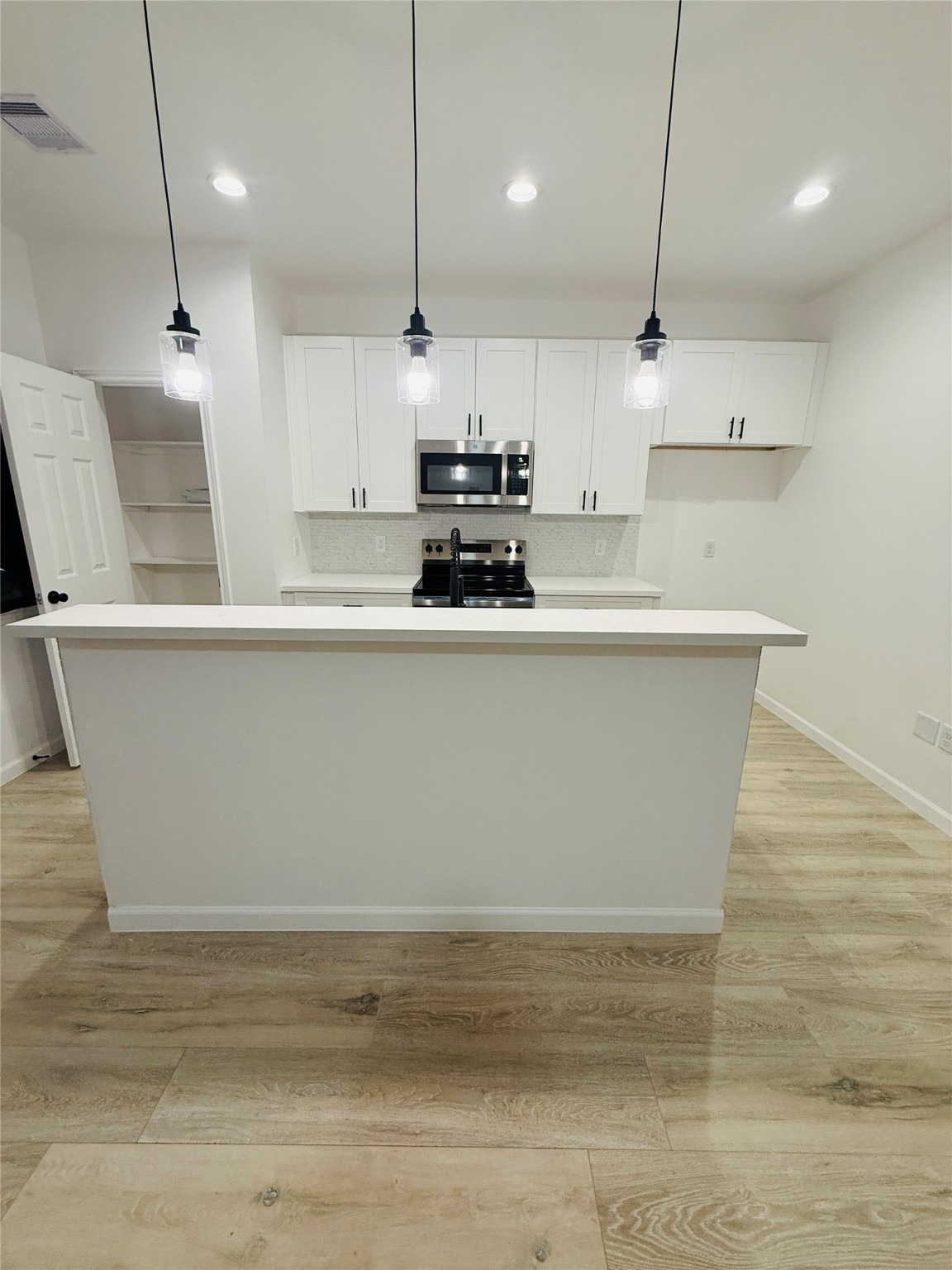 5214 Rue Street, Unit A B Houston, TX 77033 - Photo 9 of 13 a large kitchen with kitchen island a counter top a stove a sink and a refrigerator