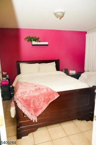 a bed with a pink blanket and pillows