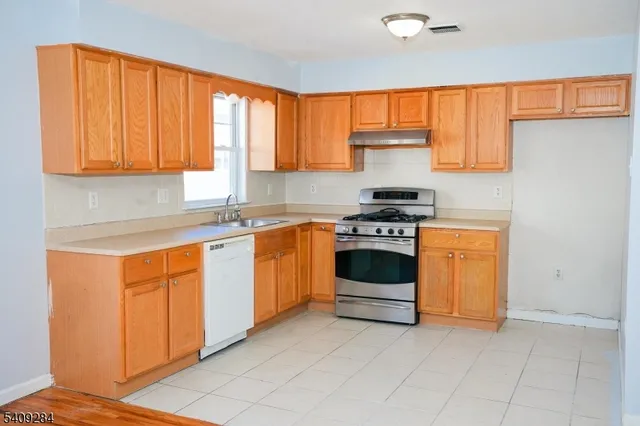 a kitchen with granite countertop white cabinets and white appliances