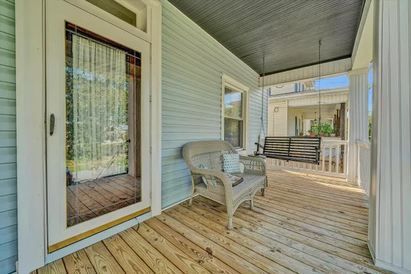 a balcony with chairs and wooden floor
