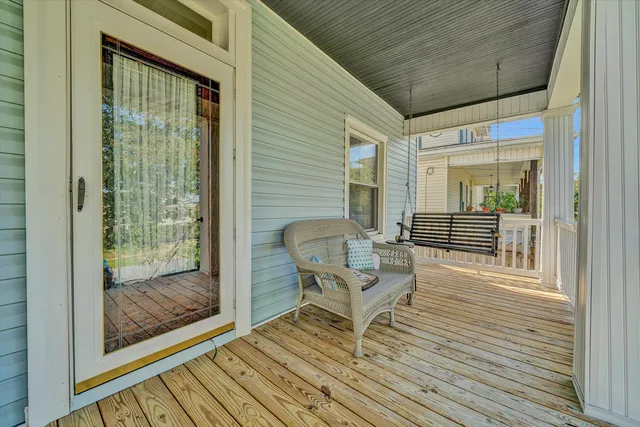 a balcony with chairs and wooden floor