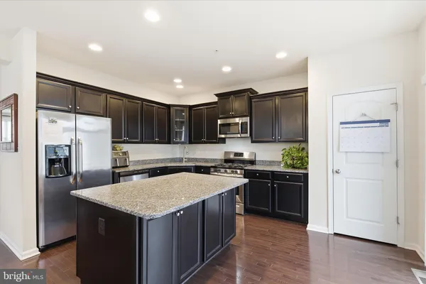 a kitchen with a refrigerator a sink and wooden cabinets