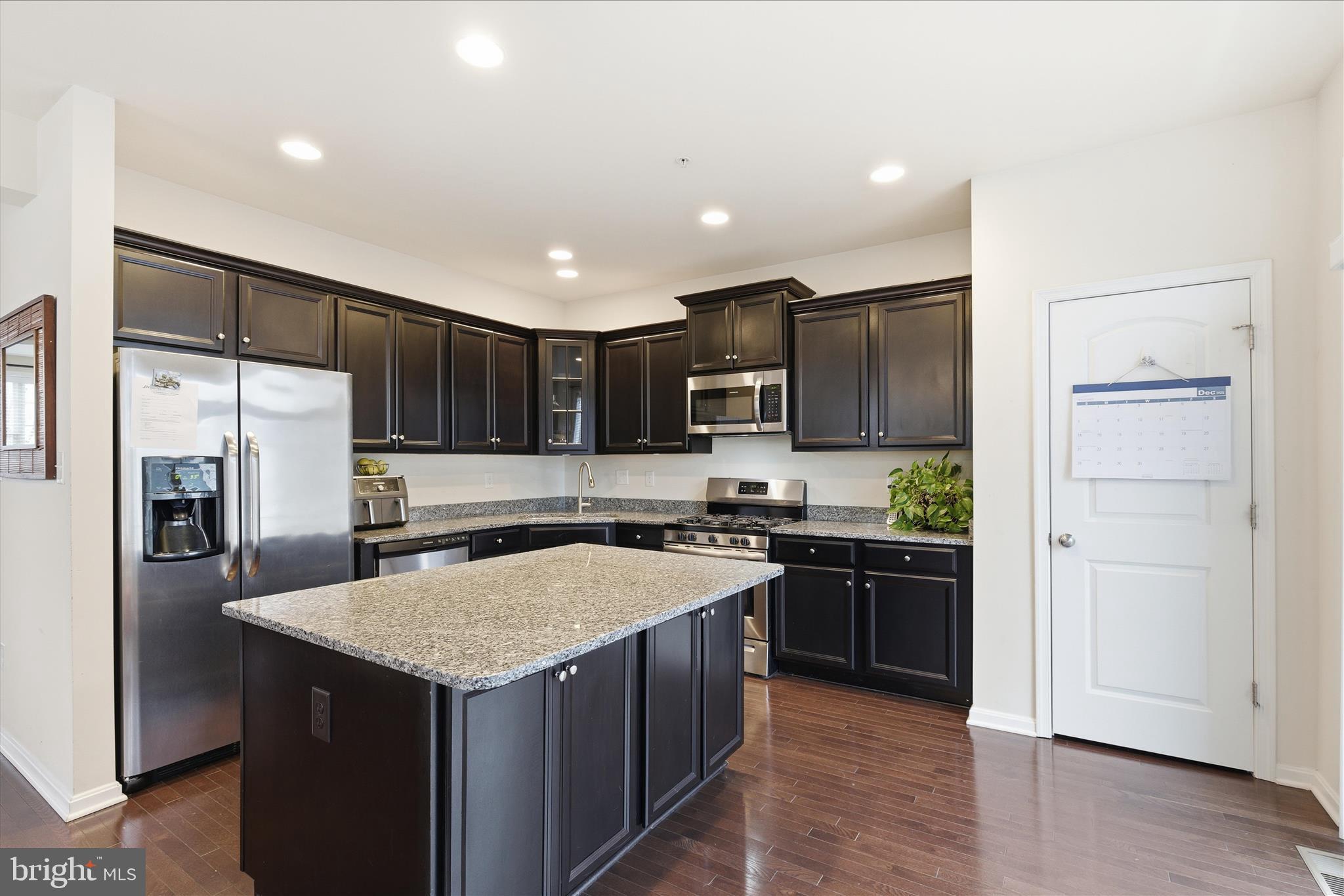 9511 Smithview Place Lanham, MD 20706 - Photo 18 of 33 a kitchen with a refrigerator a sink and wooden cabinets