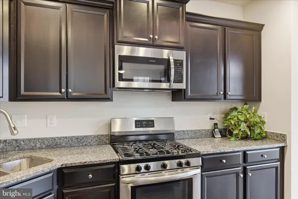 a kitchen with stainless steel appliances granite countertop a sink stove and cabinets