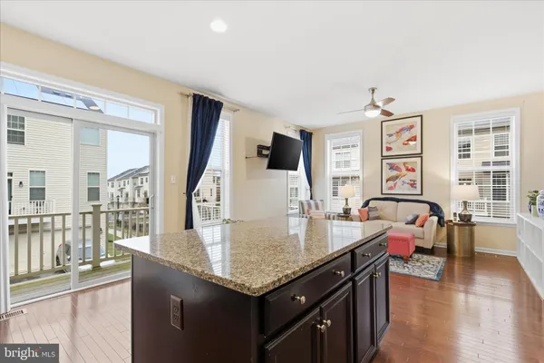 a living room with furniture a large window and wooden floor