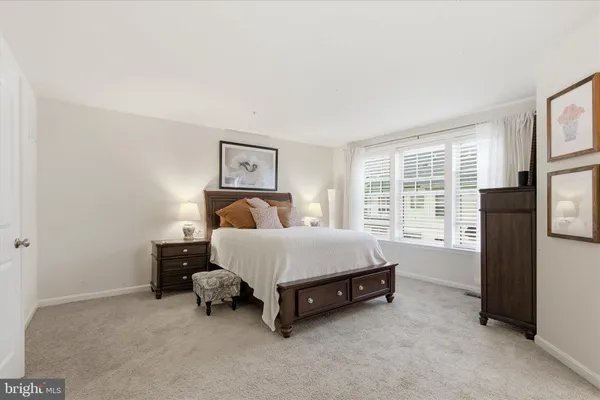 a bed sitting in a bedroom next to a window with lamp