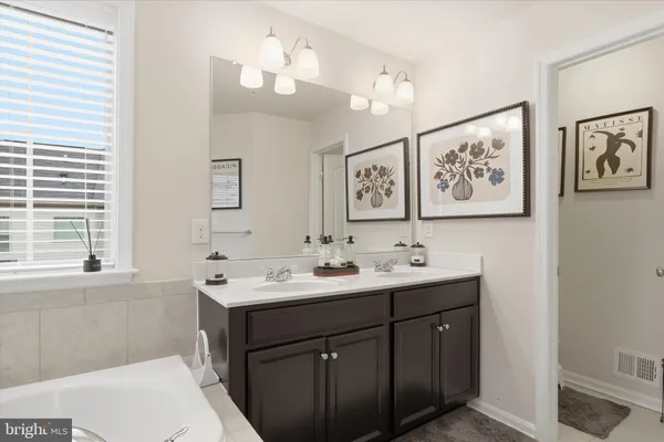 a bathroom with a sink a large mirror and a window