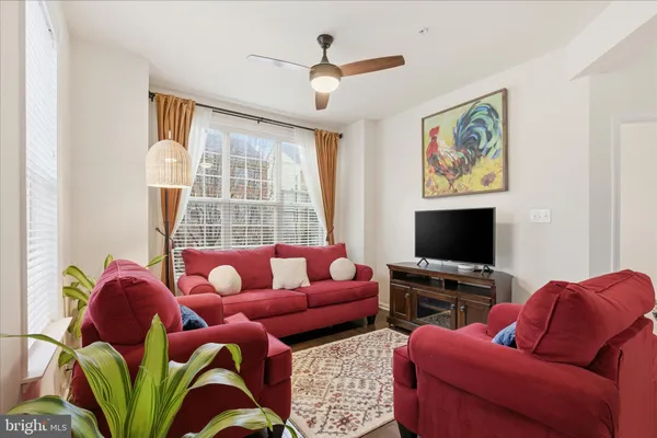 a living room with furniture a flat screen tv and a window