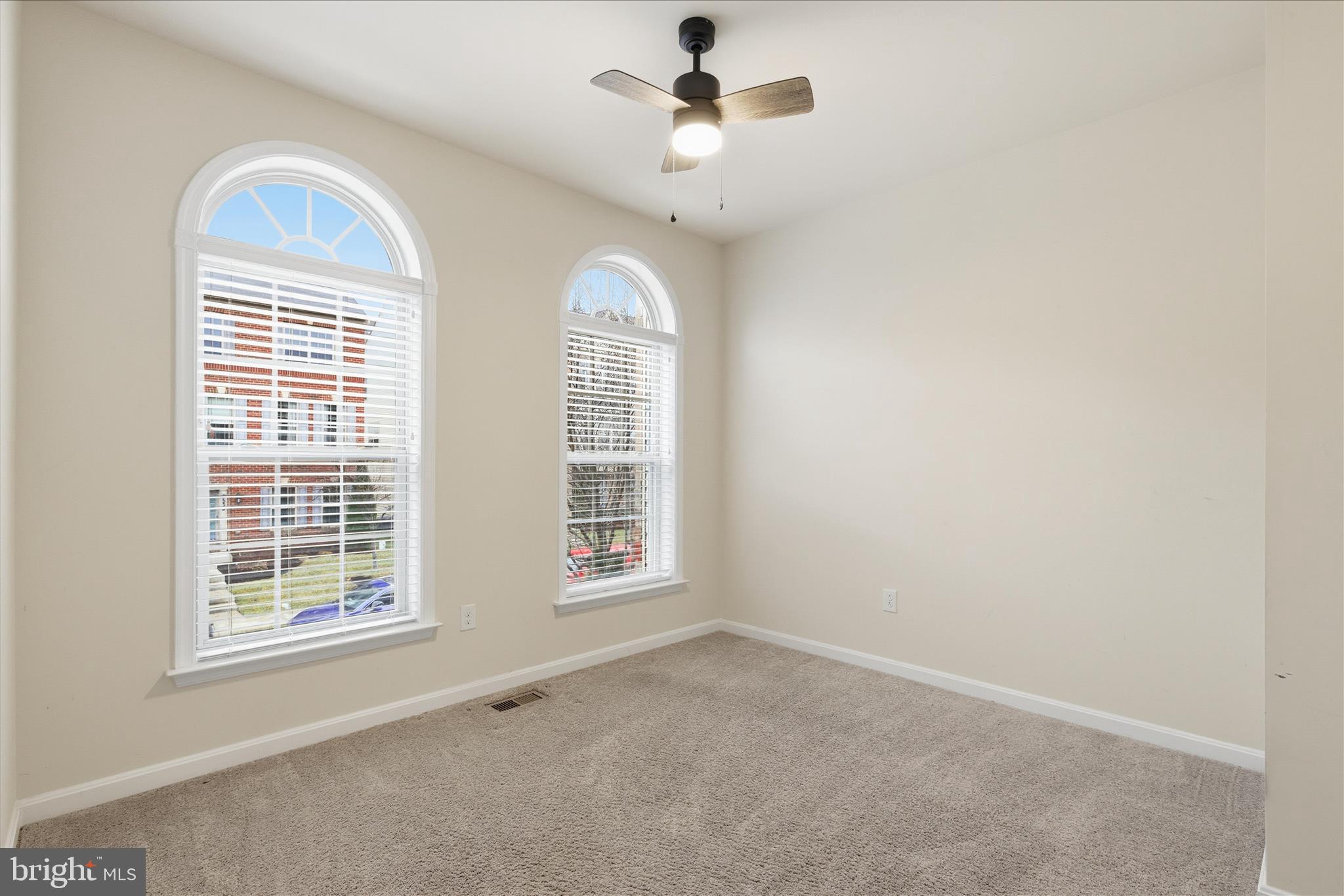 9511 Smithview Place Lanham, MD 20706 - Photo 10 of 33 an empty room with windows and chandelier fan