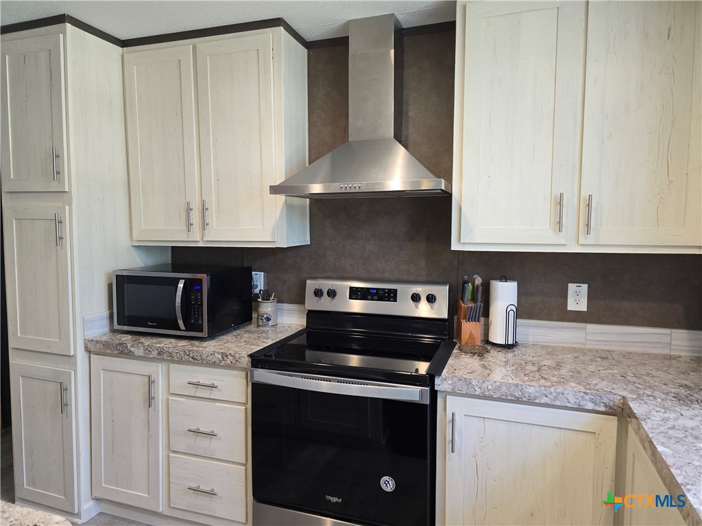 412 Coryell City Road Gatesville, TX 76528 - Photo 7 of 34 a kitchen with granite countertop white cabinets and stainless steel appliances
