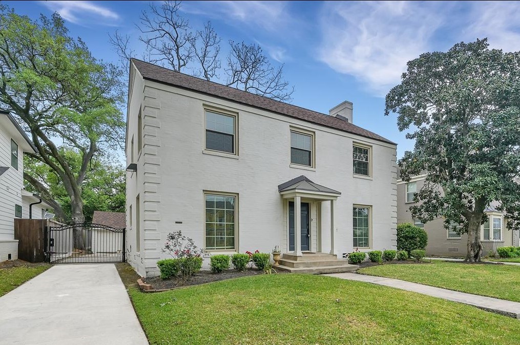 Current view of the front of the home with painted all brick exterior and automatic driveway gate.