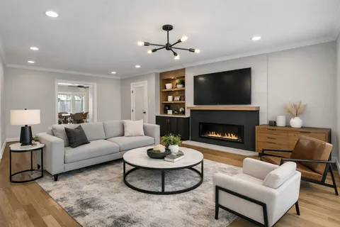 a living room with furniture a fireplace and a flat screen tv