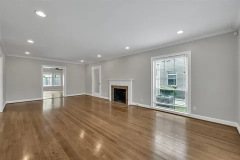 a view of empty room with wooden floor and fireplace