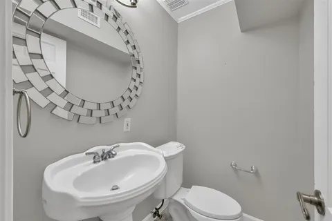 a bathroom with a sink mirror and toilet