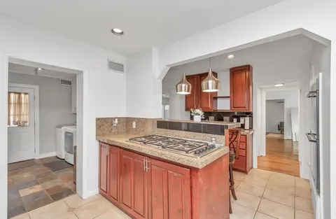 a kitchen with stainless steel appliances granite countertop a stove a sink dishwasher and a refrigerator