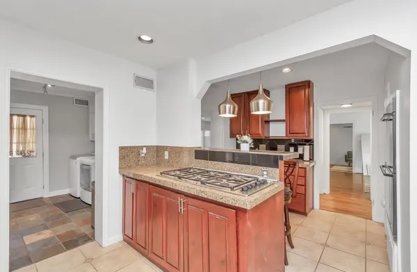 a kitchen with stainless steel appliances granite countertop a stove a sink dishwasher and a refrigerator