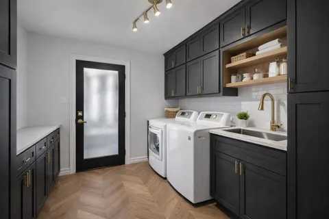 a utility room with cabinets washer and dryer