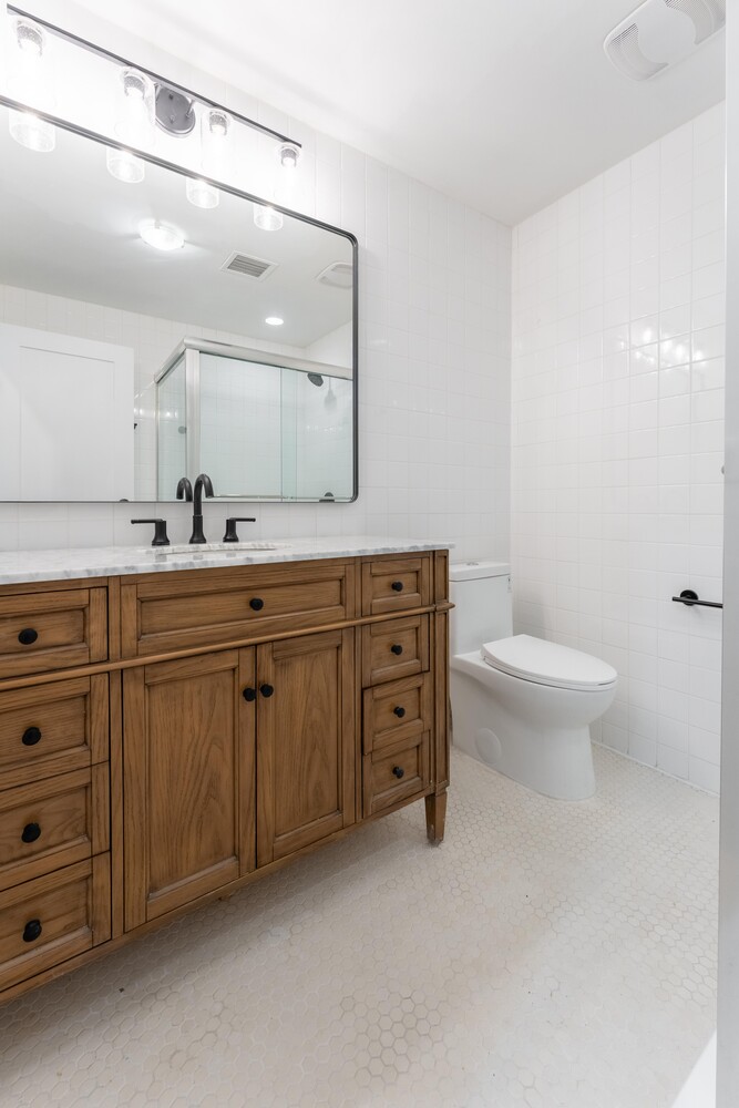 121 Division Street, Unit 2A Manhattan, NY 10002 - Photo 14 of 23 a bathroom with a double vanity sink toilet and a mirror