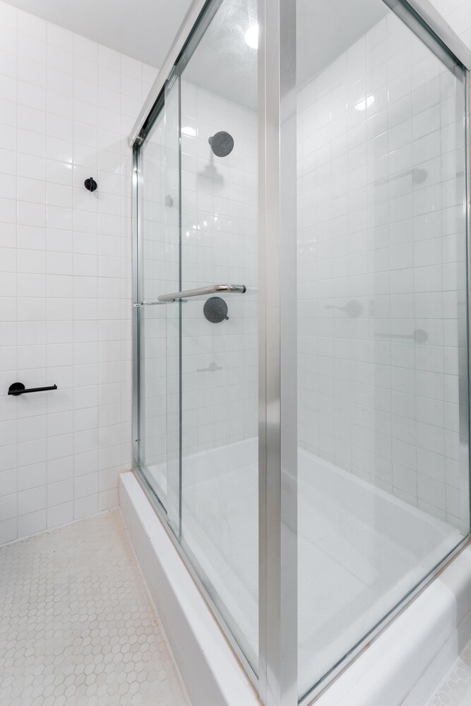 121 Division Street, Unit 2A Manhattan, NY 10002 - Photo 16 of 23 a bathroom with a shower and a glass door