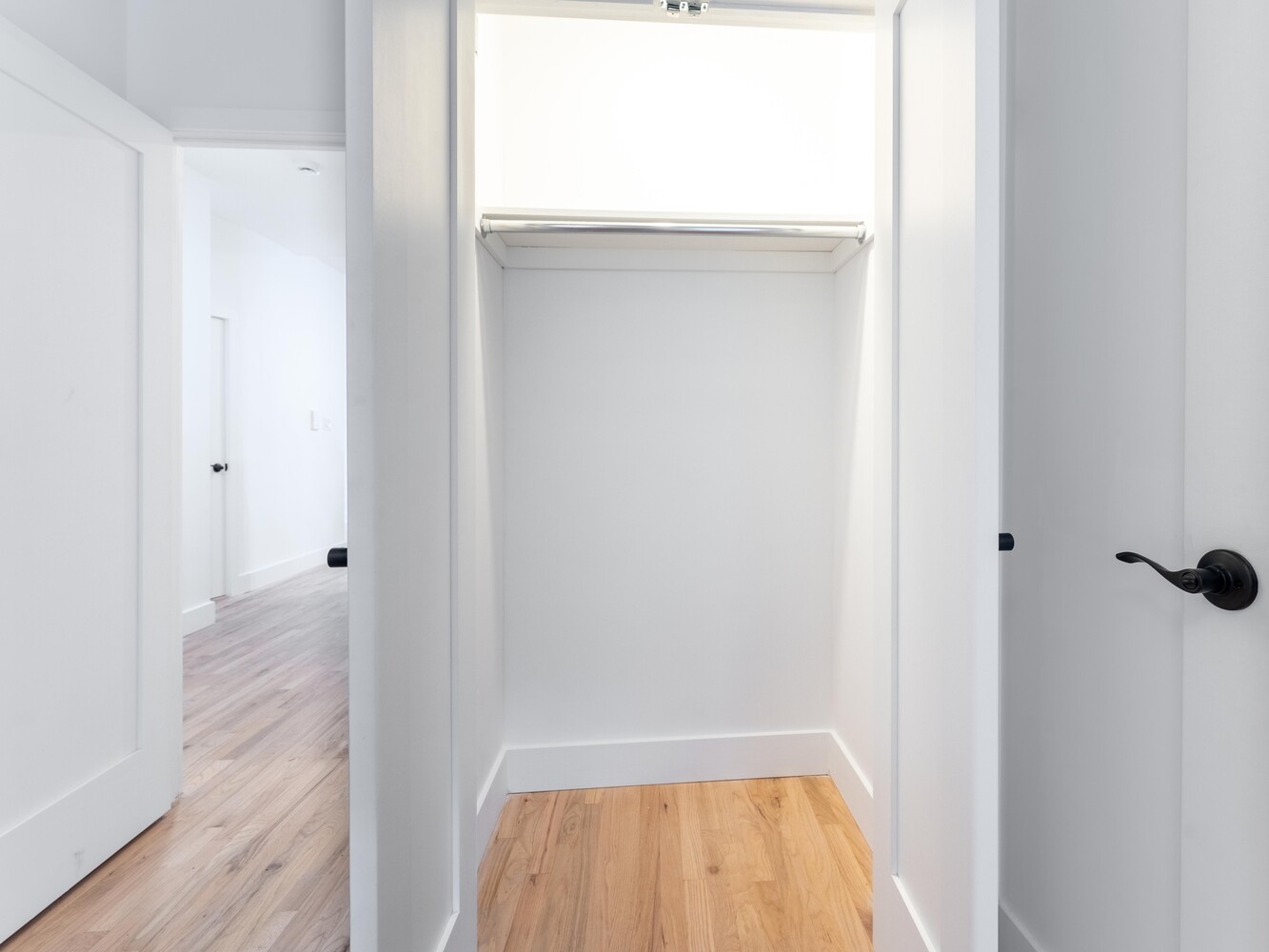 121 Division Street, Unit 2A Manhattan, NY 10002 - Photo 19 of 23 a view of a room with wooden floor and a hallway