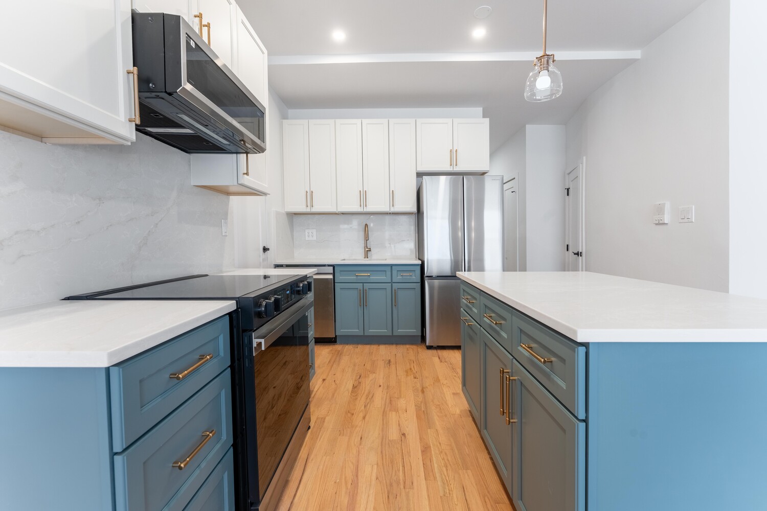 121 Division Street, Unit 2A Manhattan, NY 10002 - Photo 5 of 23 a kitchen with a stove sink and cabinets