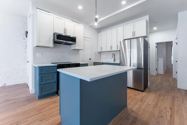 a kitchen with stainless steel appliances a stove refrigerator and a sink