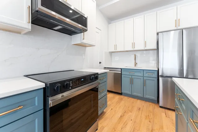 a kitchen with stainless steel appliances a refrigerator stove and microwave