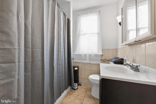 a bathroom with a sink a toilet and a window