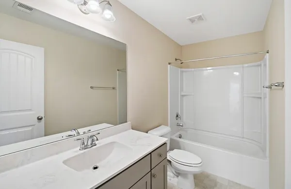a bathroom with a sink toilet mirror and shower