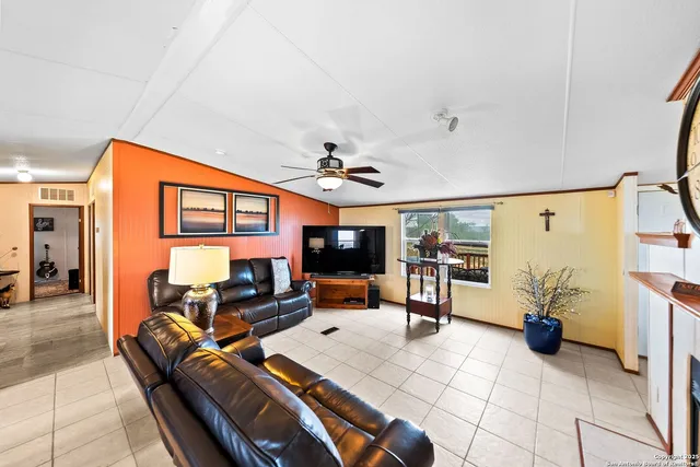 a living room with furniture a flat screen tv and kitchen view
