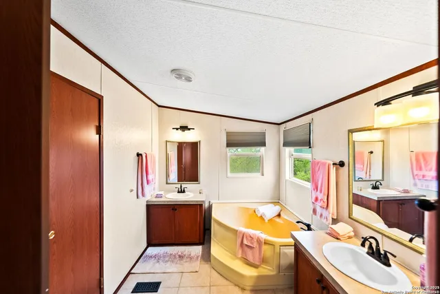 a bathroom with a tub sink and mirror