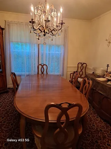 a view of a dining room with furniture and chandelier