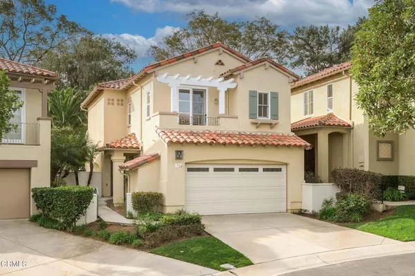 a front view of a house with a garage and outdoor seating