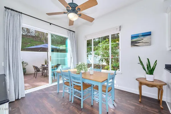 a kitchen with stainless steel appliances white cabinets a wooden floor and a window