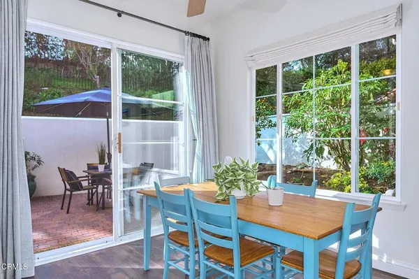 a view of a patio with table and chairs potted plants and a large tree