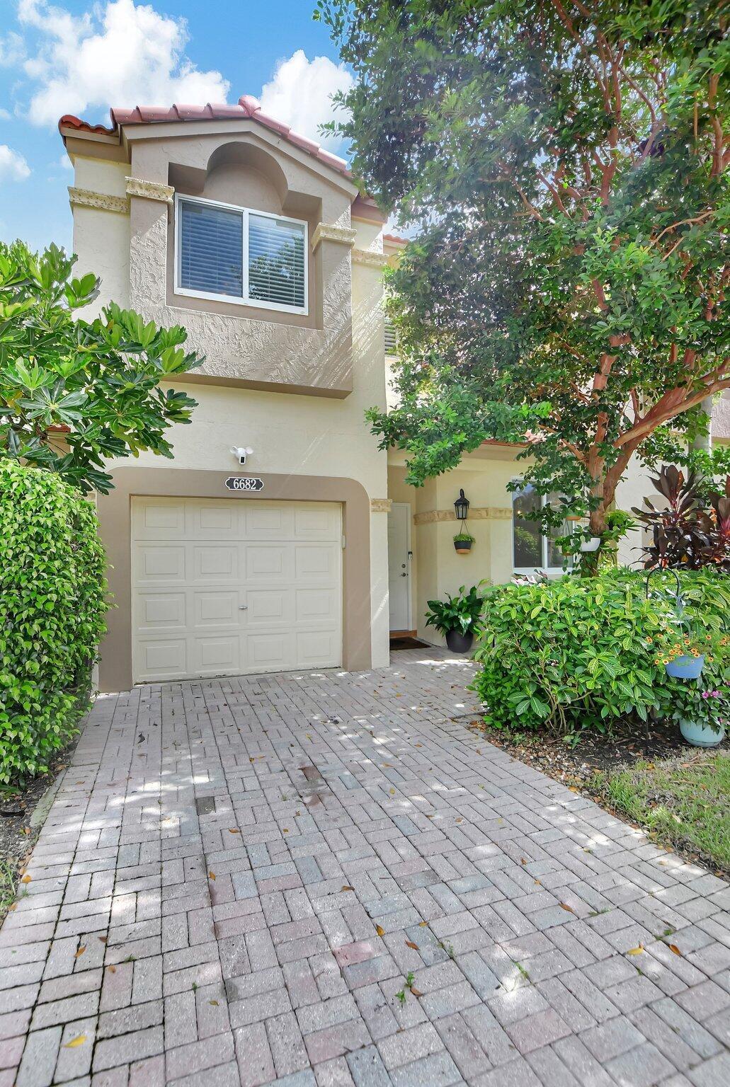 6682 Via Regina Boca Raton, FL 33433 - Photo 46 of 46 a front view of a house with a yard and a garage