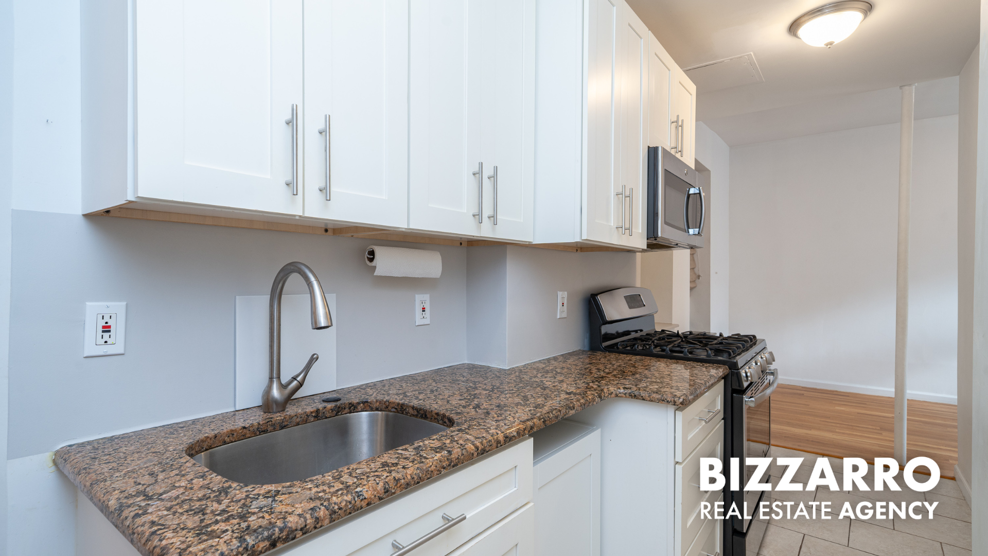 a kitchen with granite countertop a sink a stove and cabinets