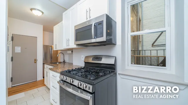 a kitchen with stainless steel appliances granite countertop a stove and a microwave