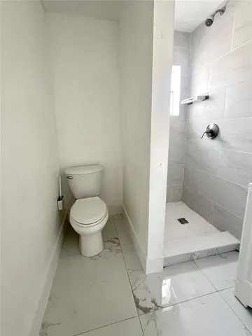 a bathroom with a toilet and a shower