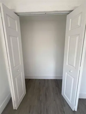 an empty room with wooden floor and a window