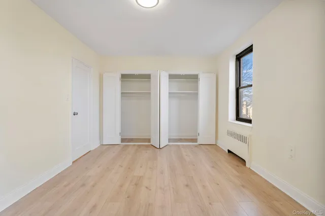 an empty room with windows and closet