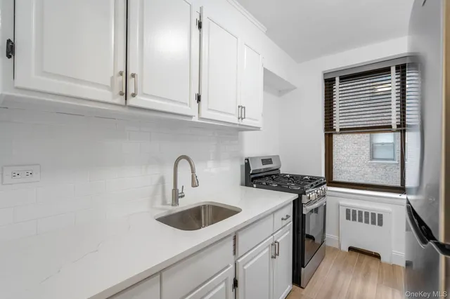 a kitchen with granite countertop a sink a stove and cabinets