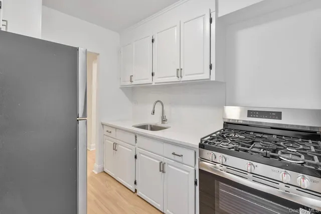 a kitchen with white cabinets and appliances