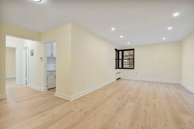 a view of a big room with wooden floor and windows