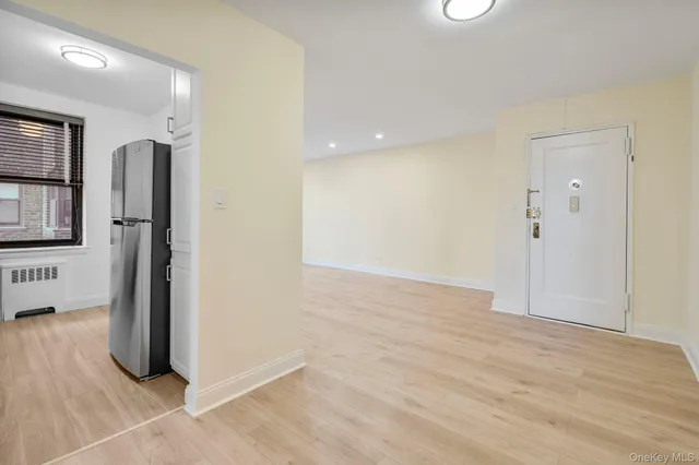 a view of empty room with wooden floor and windows