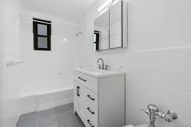 a bathroom with a bathtub sink vanity and mirror